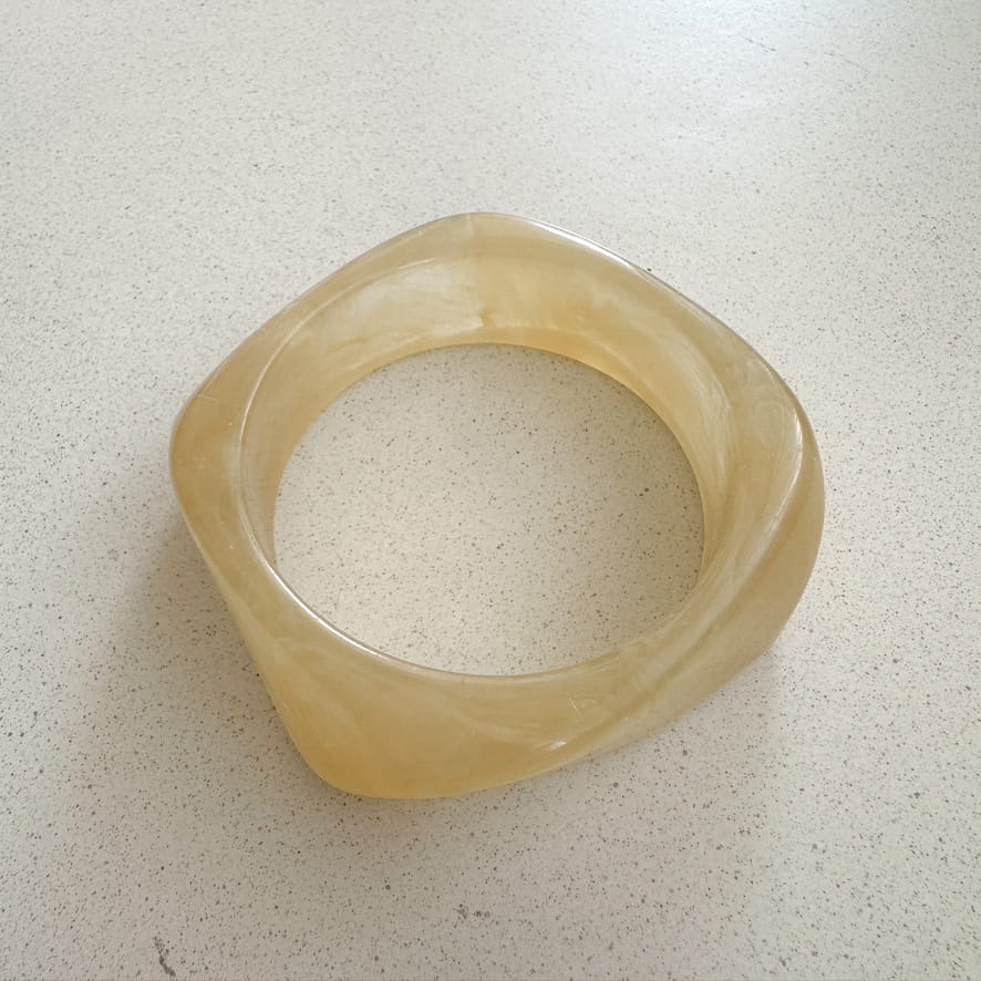 Gelber Armreifen auf neutralem Hintergrund. 