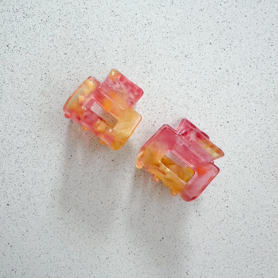 Auf dem Bild sind zwei kleine mini Haarklammer in rosa zu sehen, die Haarklammen werden als Produktfoto auf einem neutralen Hintergrund präsentiert.