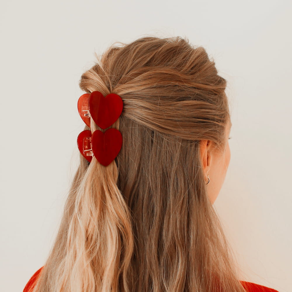 zwei kleine rote Herzhaarklammern getragen als half up hairstyle