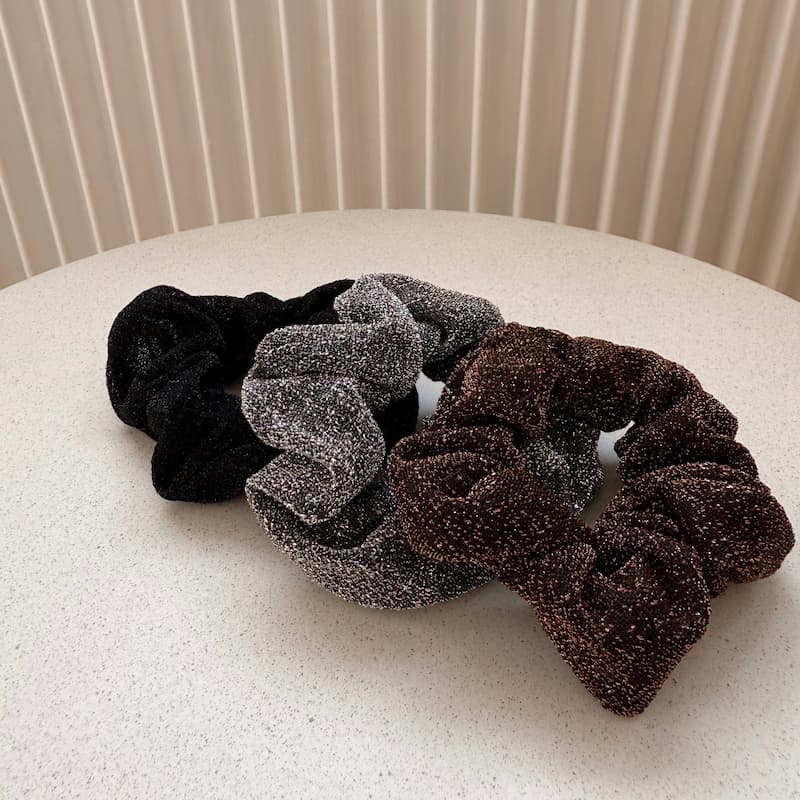 Drei Stück glitzer Scrunchies (schwarz, silber, braun). 