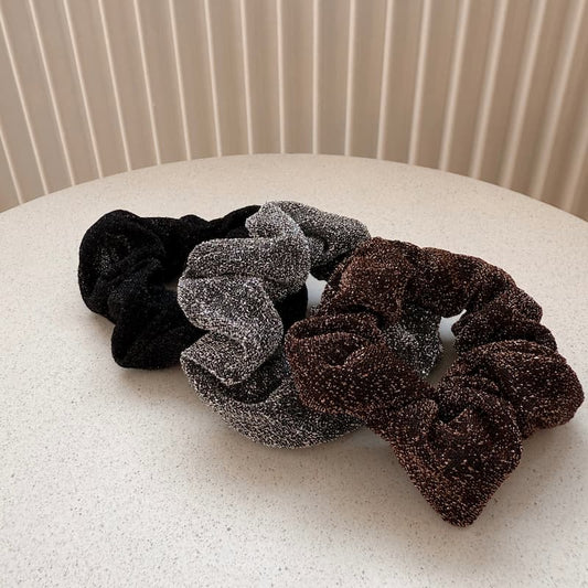 Drei Stück glitzer Scrunchies (schwarz, silber, braun). 
