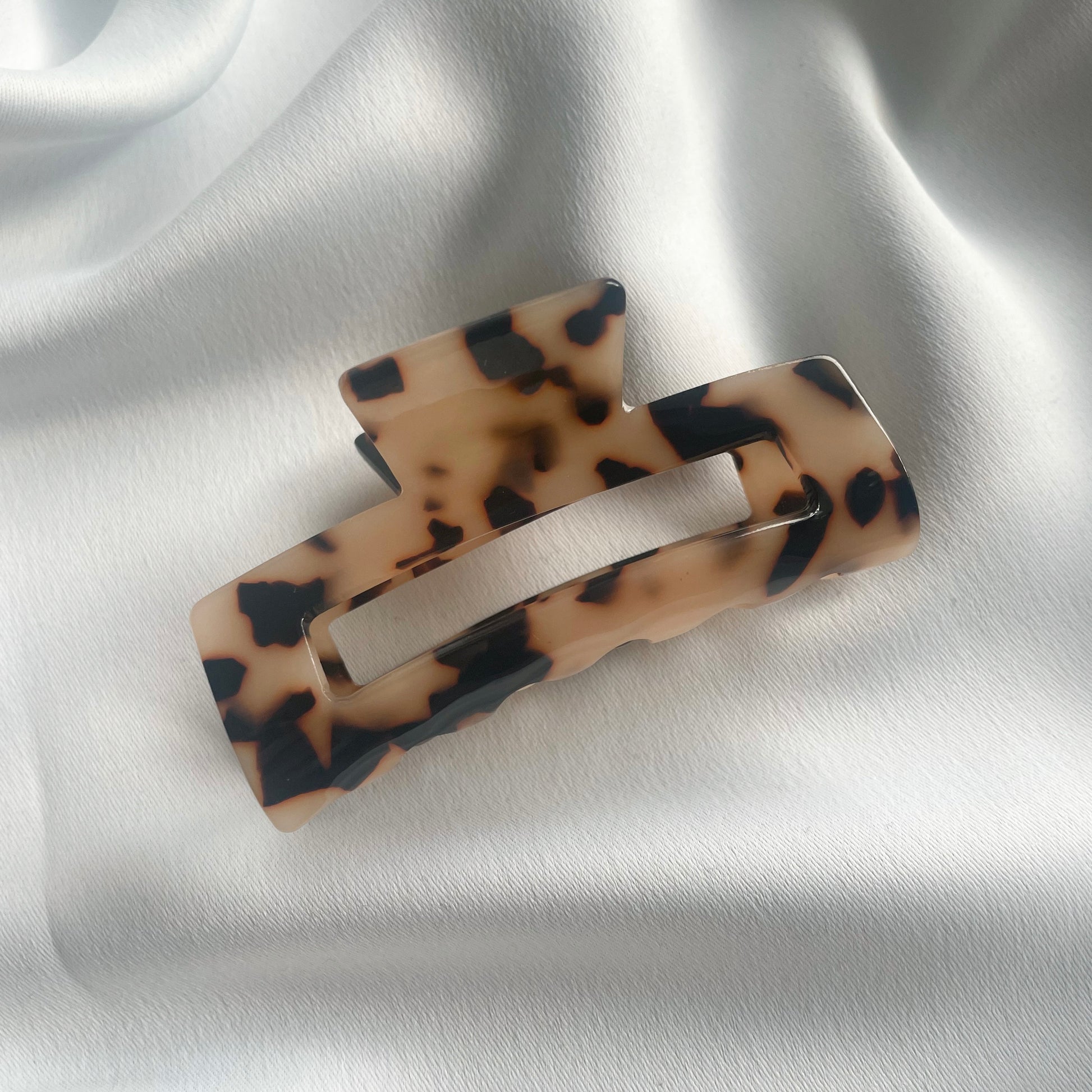 Eine mittelgrosse Haarspange (7cm)in tortoise auf einem weissen samtigen Tuch