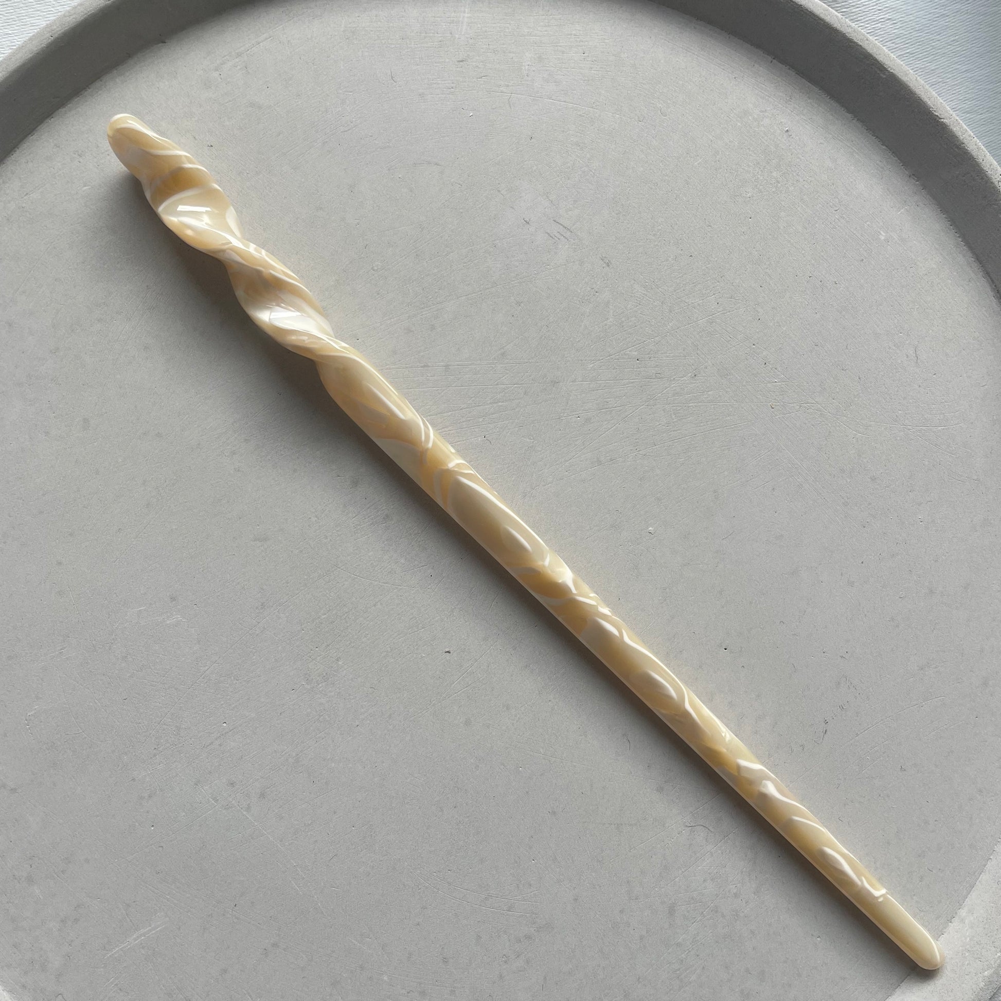 Haarstab in beige mit weissen Details. 