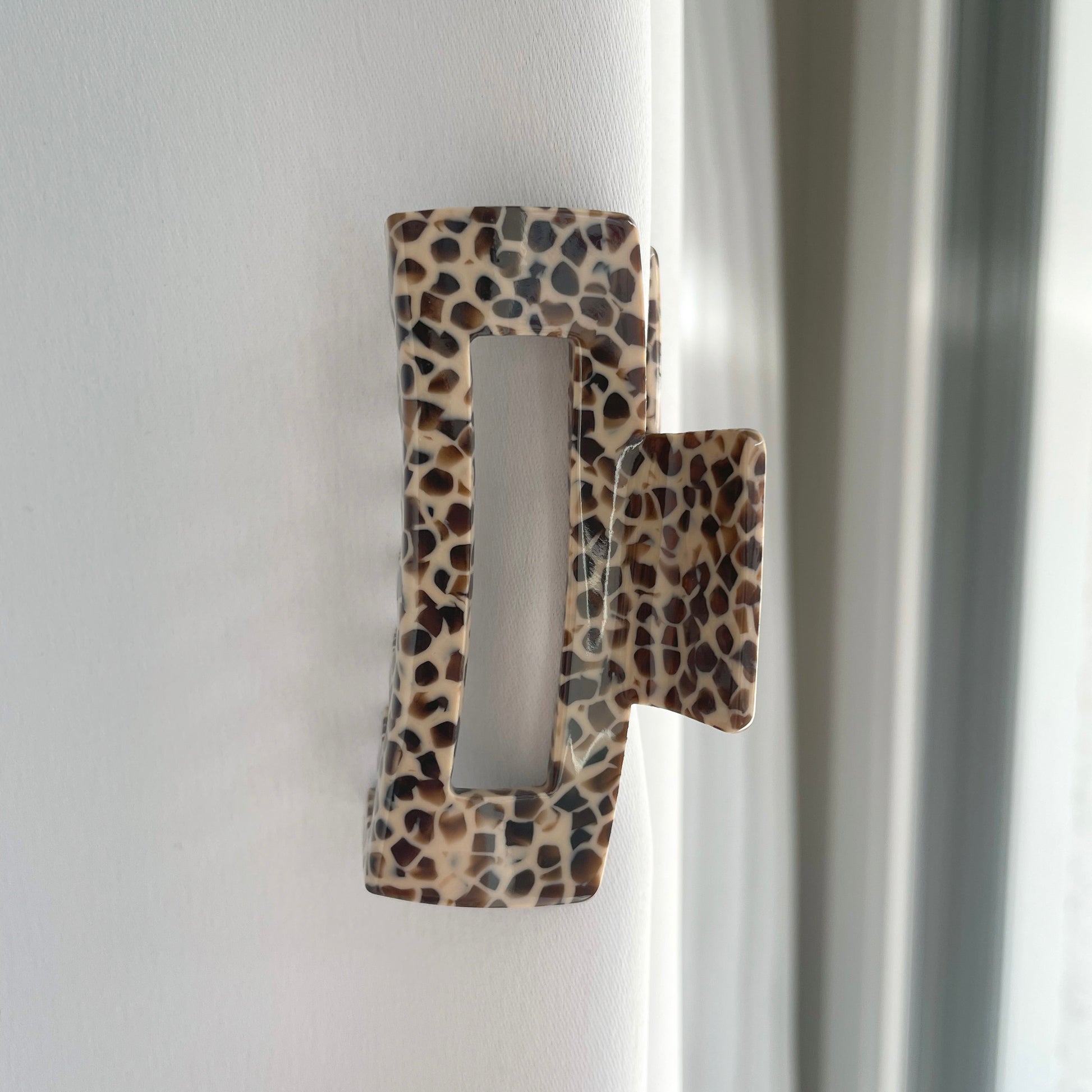 eine mittelgrosse längliche Haarspange in braun mit einem Muster welches an chocolate chips erinnert