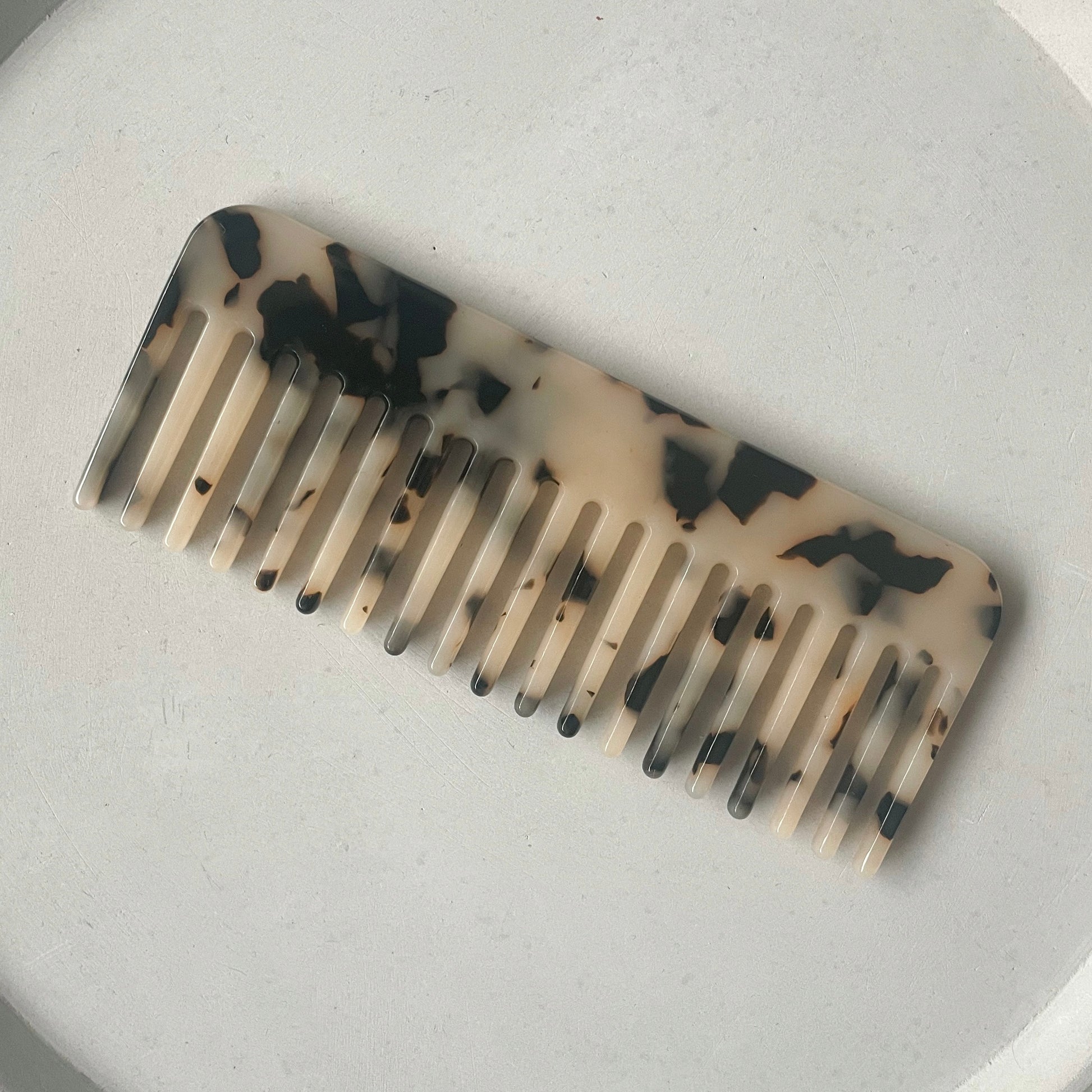 Haarkamm in tortoise auf einem grauen Hintergrund