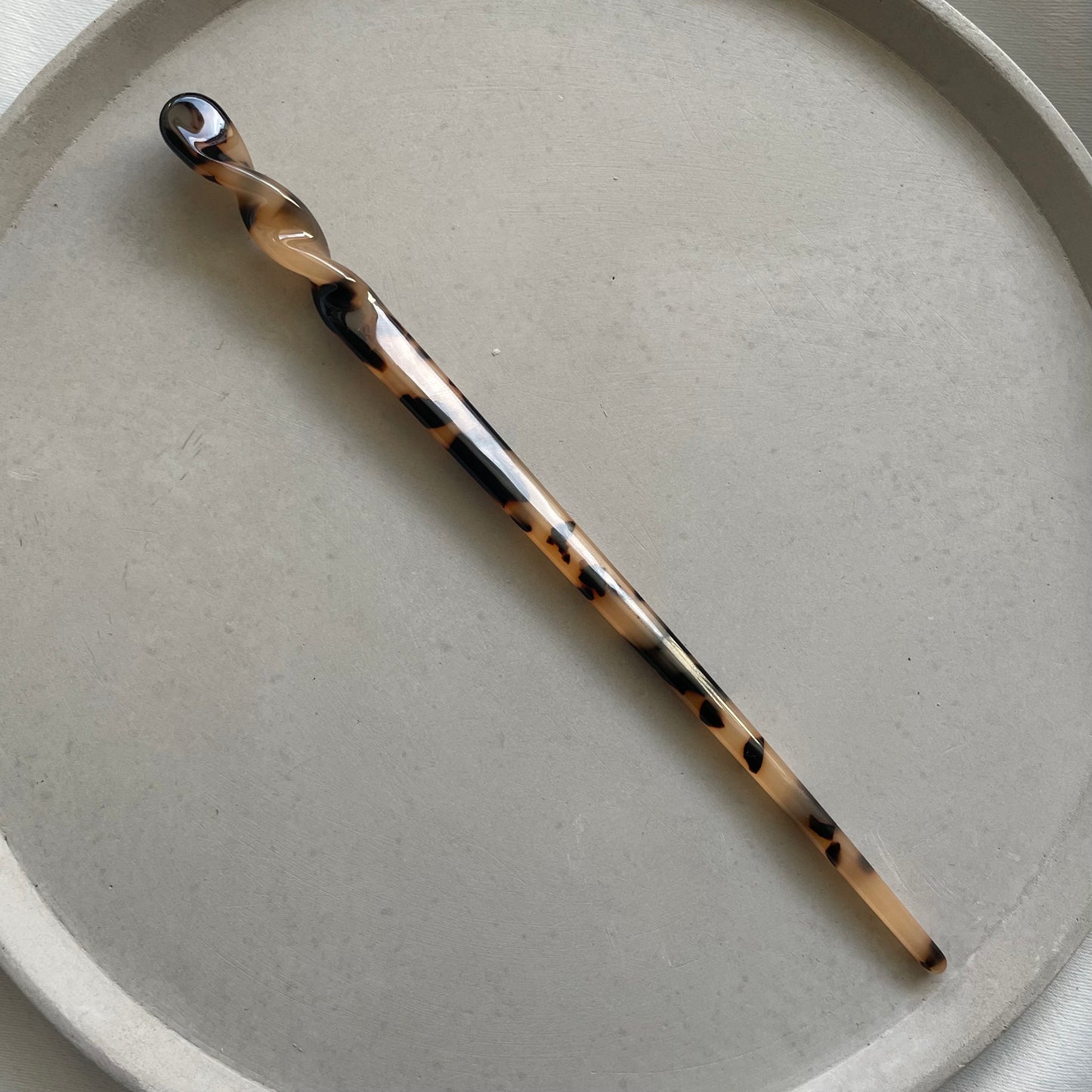 Hairpin in tortoise in einer grauen Schmuckschale. 